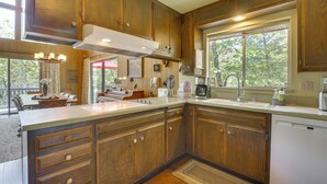 A kitchen with wooden cabinets, a large island, and a dishwasher. - Lake Arrowhead Family Home w/ Game Room (Lake Arrowhead)