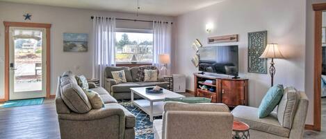 A spacious living room with a ceiling fan, a television, and a fireplace.