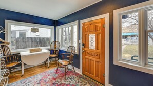 A room with a wooden door, a white table, and two wooden chairs. - 0601: Downtown Salida Cottage w/ Fireplace + Yard (Salida)
