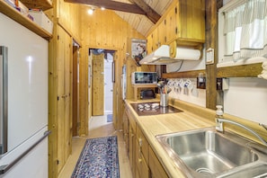 A wooden interior with a kitchen area featuring a sink, a microwave, and a toaster. - 6 Mi to Grandfather Mtn: Lake Cottage w/ Deck (Newland)
