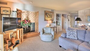 A living room with a TV, a fireplace, a sofa, and a chair. - Fireplace, Pool Access: Waterfront Hot Springs Gem (Hot Springs)
