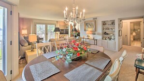 A dining area with a chandelier, a floral centerpiece, and a view of the kitchen and living room. - Fireplace, Pool Access: Waterfront Hot Springs Gem (Hot Springs)