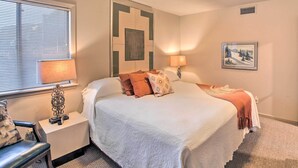 A neatly arranged hotel room with a bed, bedside lamps, a chair, and a window with blinds. - Fireplace, Pool Access: Waterfront Hot Springs Gem (Hot Springs)