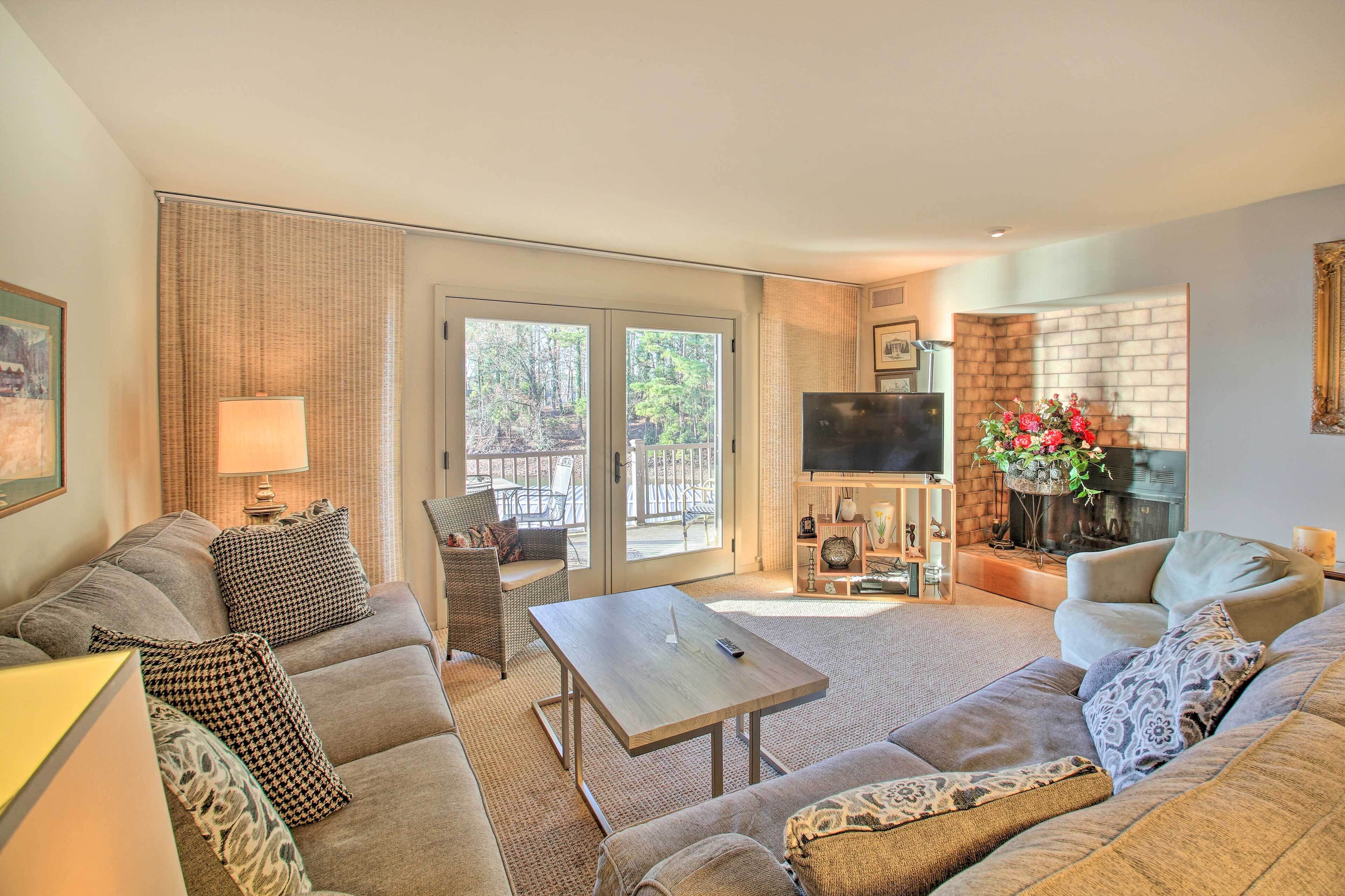 A living room with a sofa, a coffee table, a TV, and a fireplace.