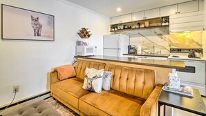 A modern kitchen with white cabinets, a marble backsplash, and a white refrigerator. - Cozy Breckenridge Condo: Free Ski Shuttle Access! (Breckenridge)