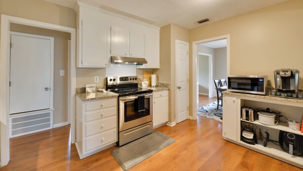 A kitchen with white cabinets, stainless steel appliances, and a microwave. - Cozy Home w/ Fenced Yard < 1 Mi Downtown Matthews! (Matthews)