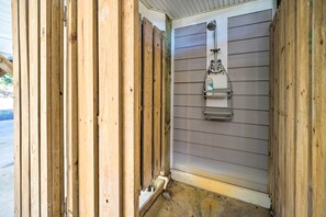 Een smalle badkamer met houten wanden en een douchehoek.