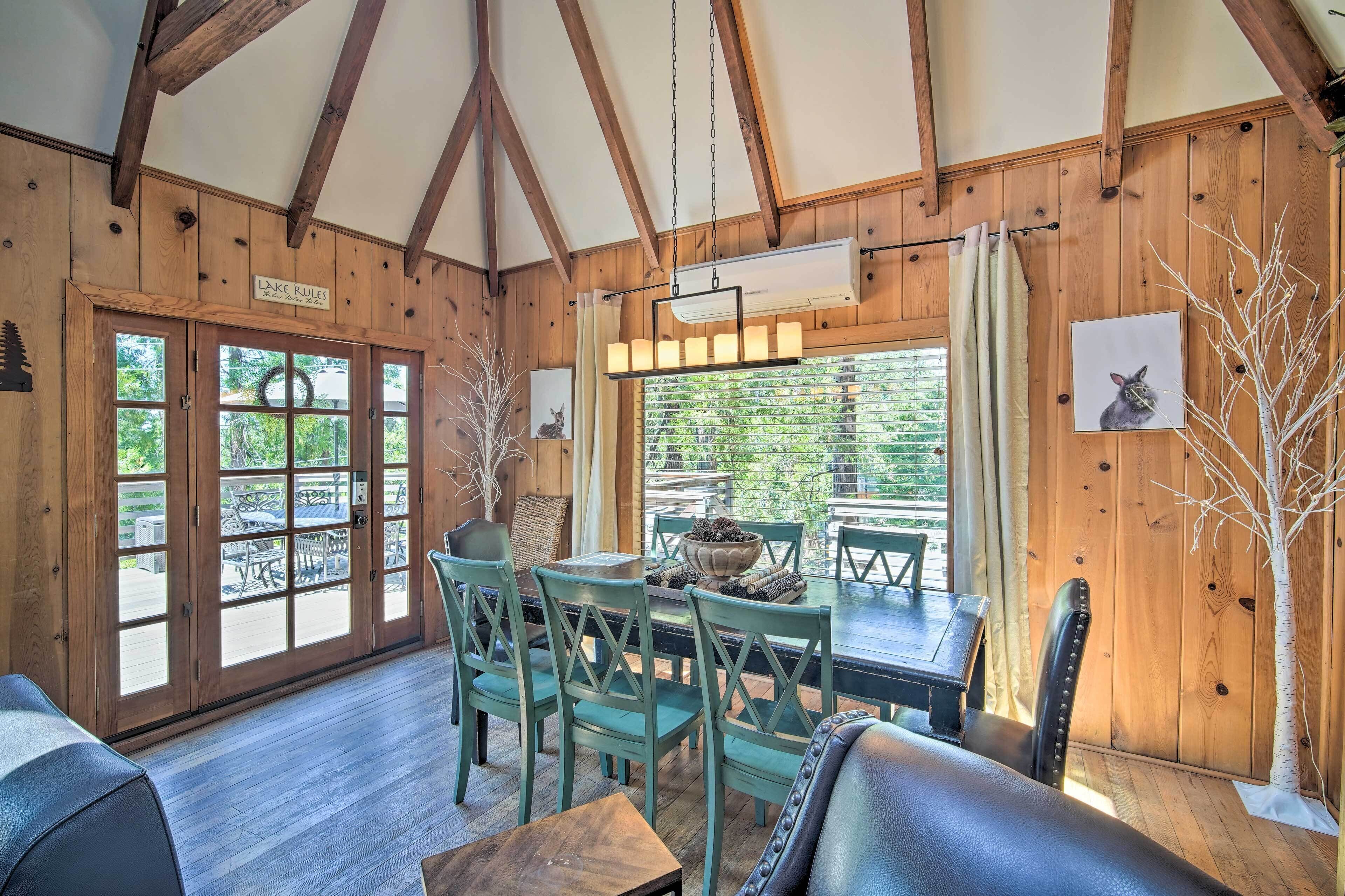 A wooden interior with a dining area, a sofa, and a sign reading "Lake Rules."