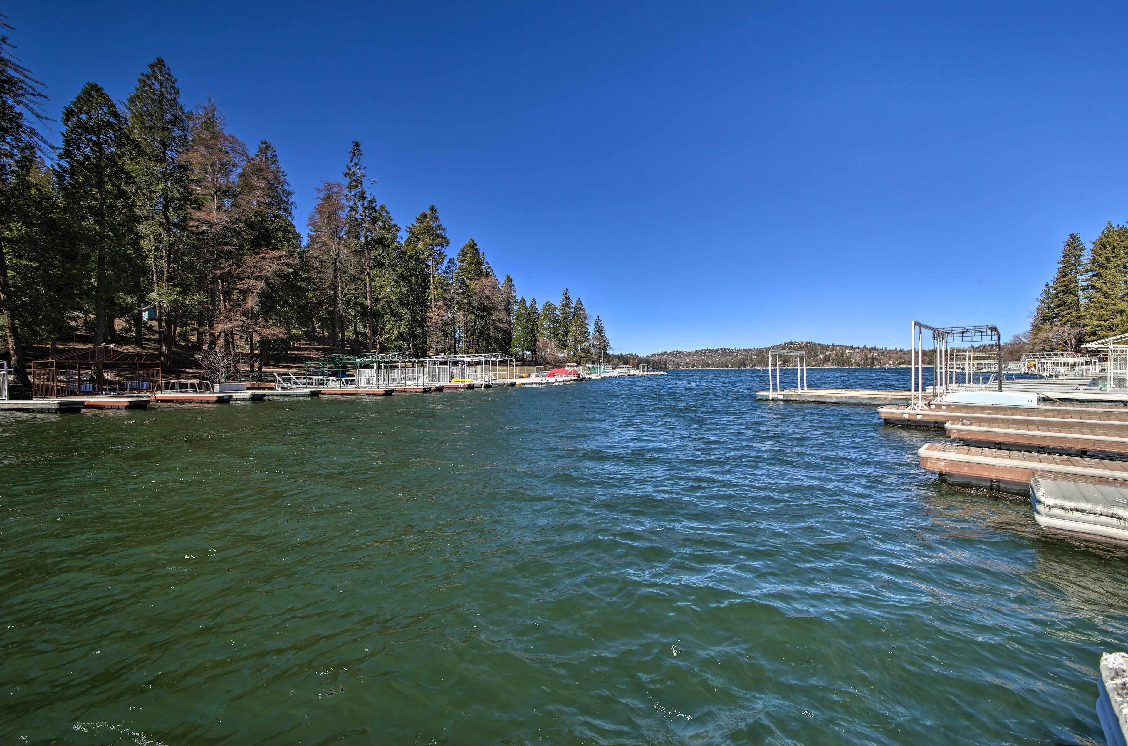 A calm lake with docked boats and a pier extending into the water.