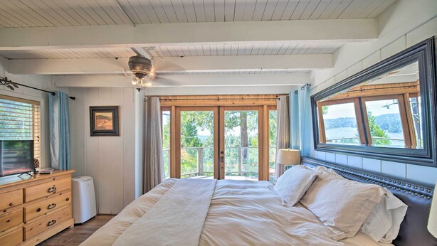 A bedroom with a large bed, wooden dresser, and a ceiling fan. - Lakeview Lodge Fit for Groups < 1 Mile to Lake! (Cedar Glen)