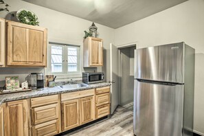 A kitchen with wooden cabinets, a stainless steel refrigerator, a microwave, and a sink. - High-end & Homey Family Abode: Walk Downtown! (Coeur d'Alene)