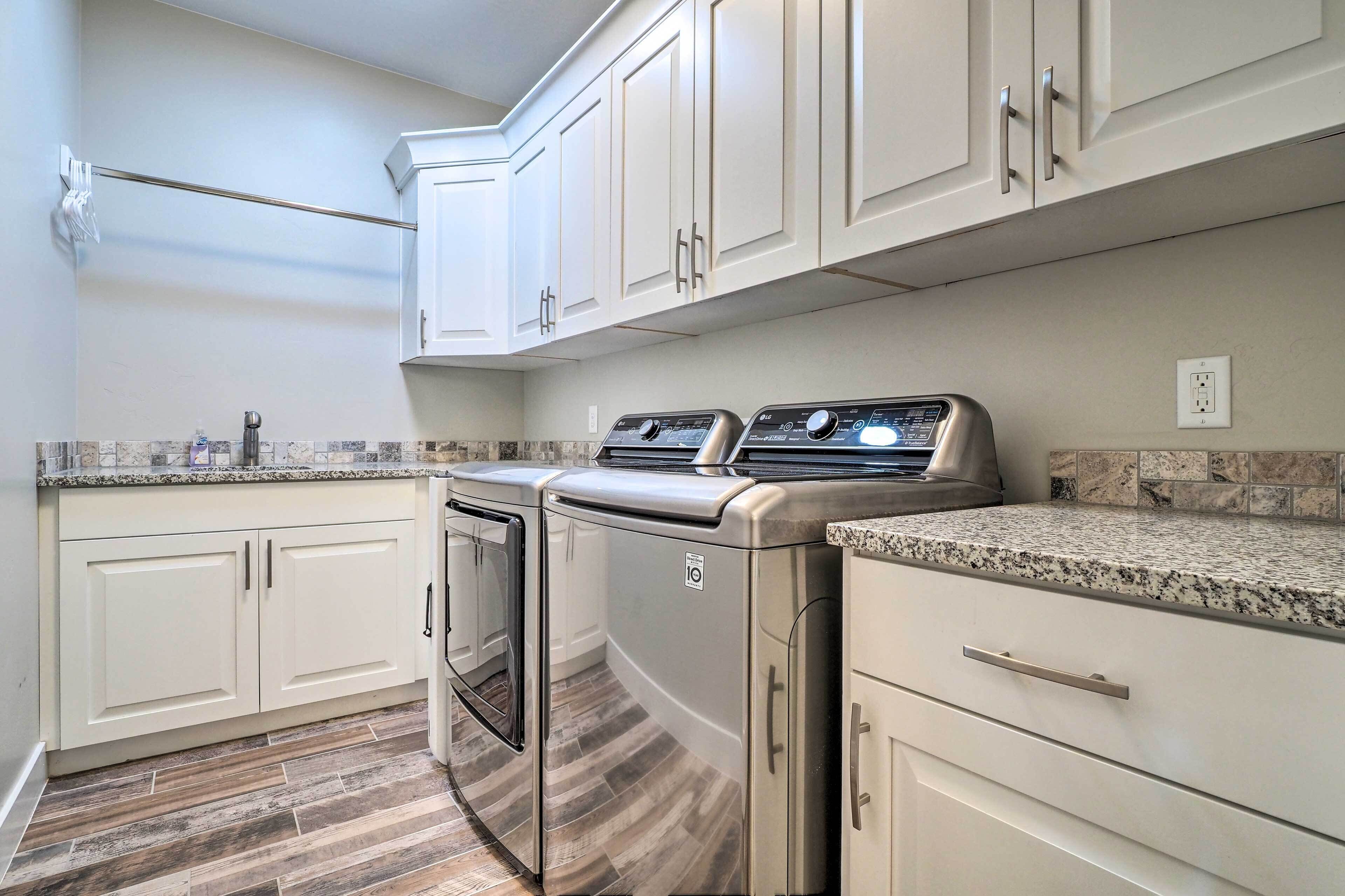 A kitchen with white cabinets, a stainless steel range, and a granite countertop.