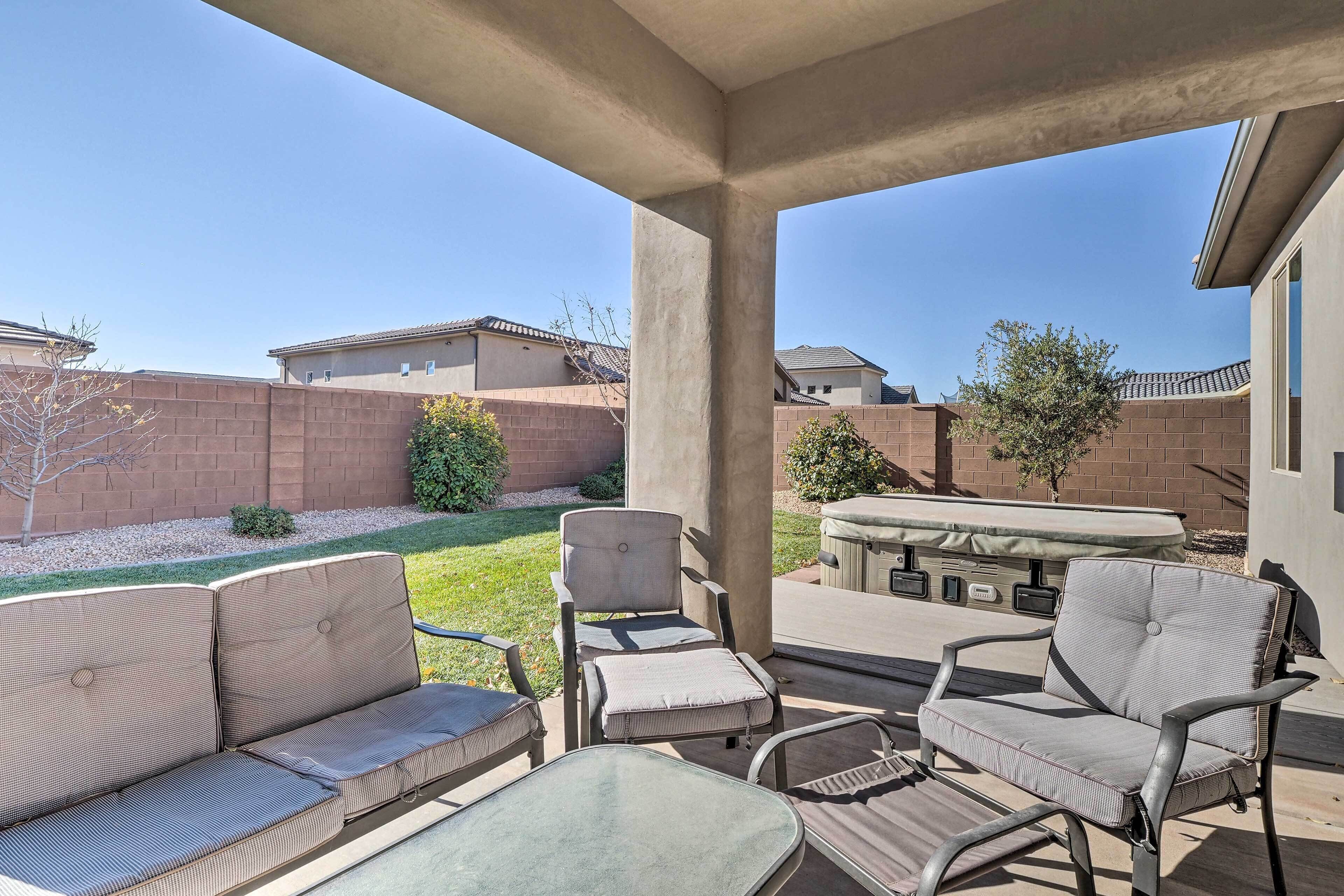 An outdoor patio area with a sofa, chairs, and a table.