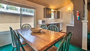A dining area with a wooden table, chairs, and a large woven bowl.