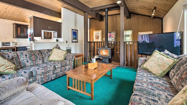 A cozy living room with patterned sofas, a wooden coffee table, and a fireplace.