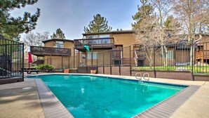 A rectangular swimming pool with a tiled edge, surrounded by a concrete deck.