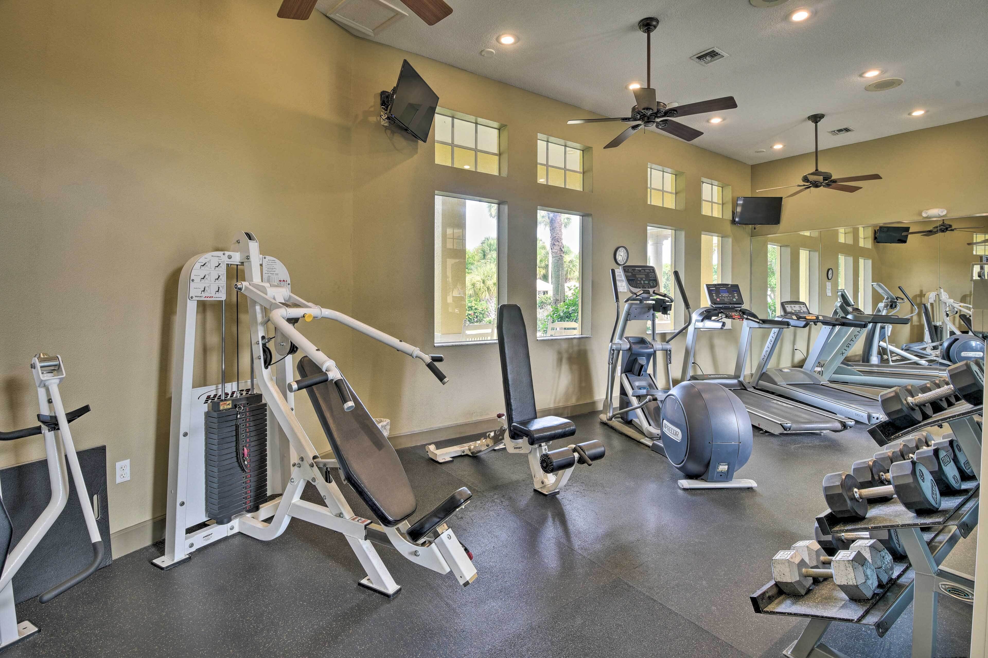 A gym with various exercise equipment, including treadmills, dumbbells, and weight machines.