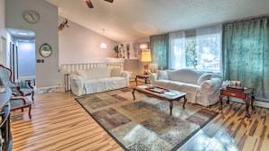 A living room with a ceiling fan, two white sofas, a coffee table, and a patterned rug. - Scenic Woodland Park Cottage w/ Deck + Grill! (Woodland Park)