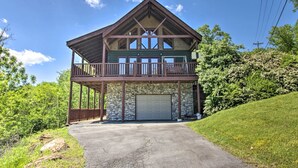 Une maison à deux étages avec un balcon, un garage et une allée.