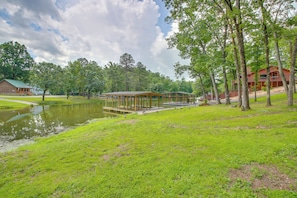 A lakeside lodge with a dock, a covered picnic area, and a large building with a red roof. - Lakefront Arkansas Home w/ Dock & Sunroom (Hot Springs)