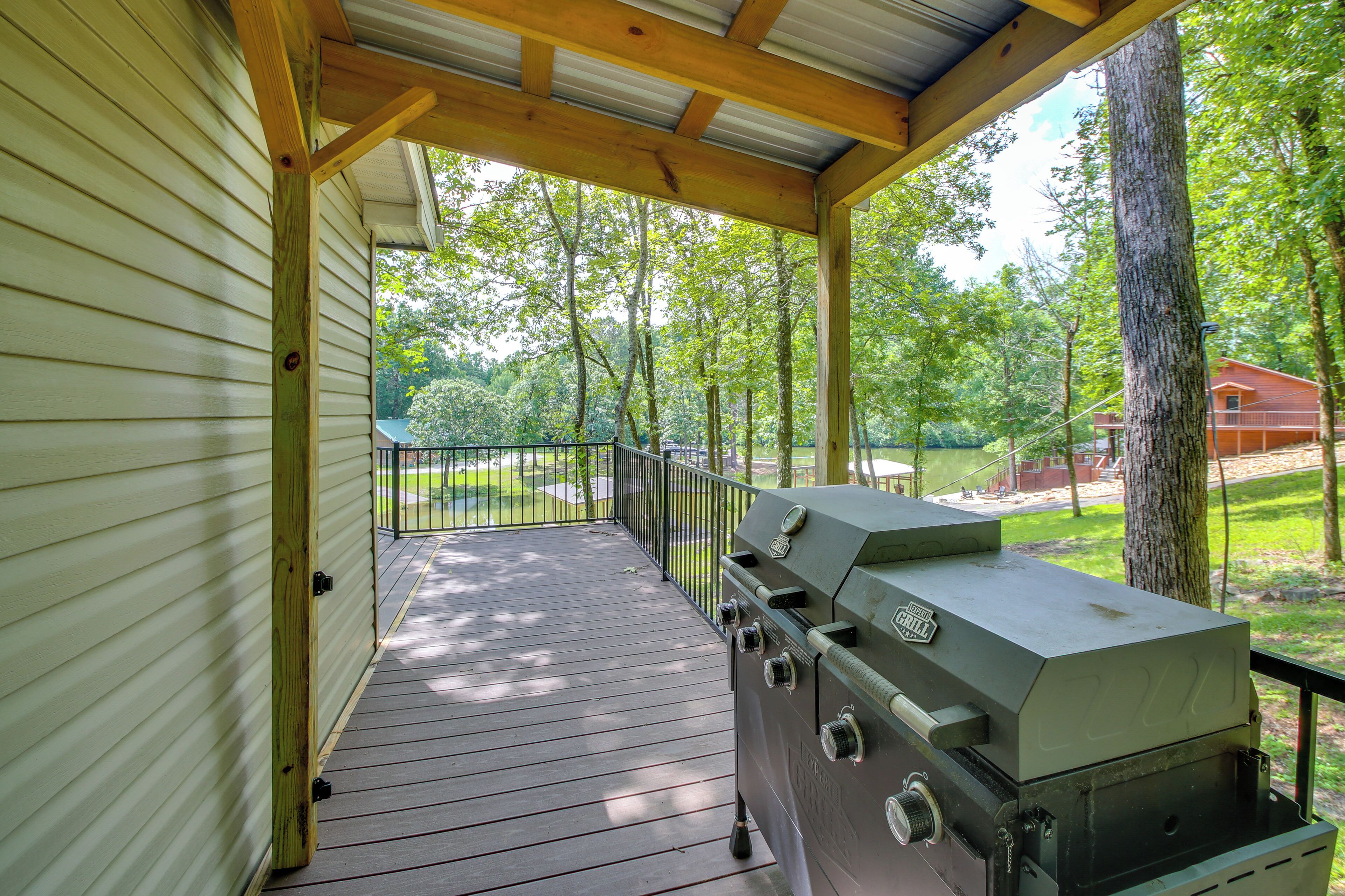 Eine überdachte Terrasse im Freien mit Grill, Holzbalken und Blick auf einen Park.