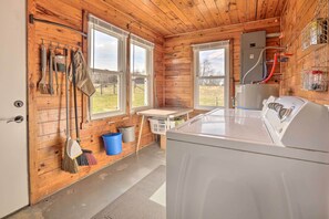 A laundry room with a washing machine, a broom, a dustpan, and a bucket. - Family Home w/ Deck, 2 Mi to Lake Cumberland (Monticello)