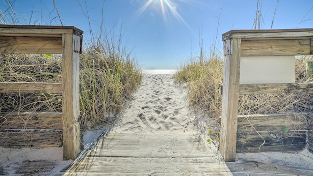 A wooden pathway leading to a beach with a clear sky and sun shining. - Oceanfront Panama City Beach Condo w/ Balcony! (Panama City Beach)