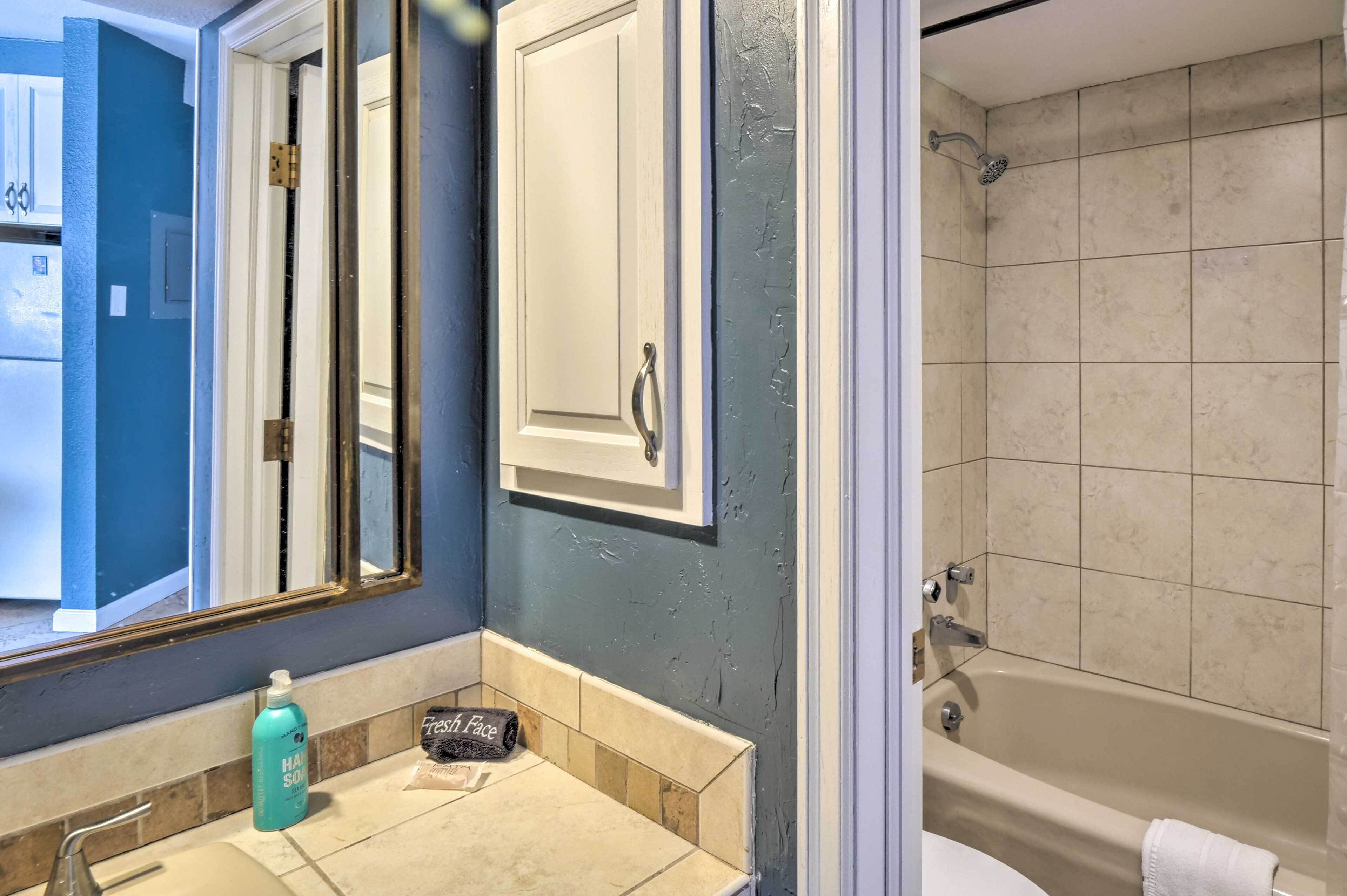 Une salle de bain avec une baignoire, un lavabo et un miroir.