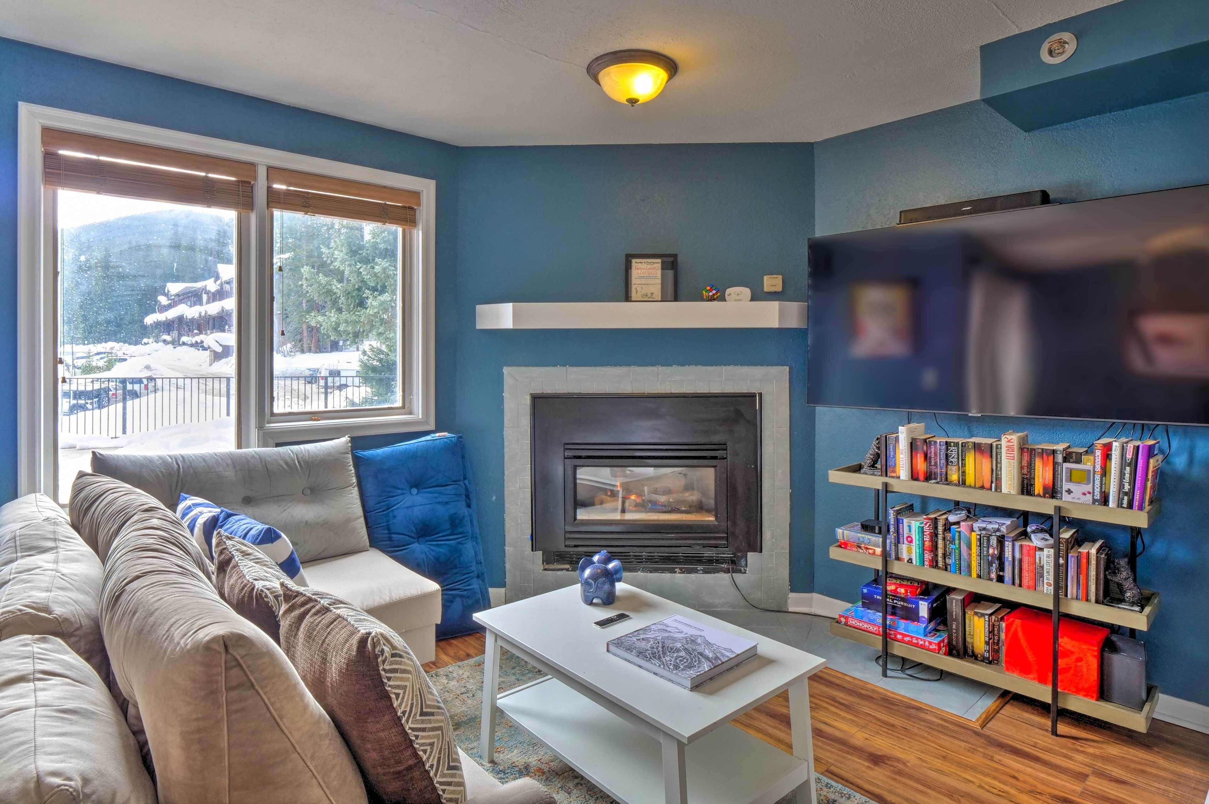 A living room with a sofa, a fireplace, a bookshelf, and a TV.