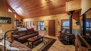 Ein gemütliches Holzhaus-Interieur mit Sofa, Couchtisch und Kamin.