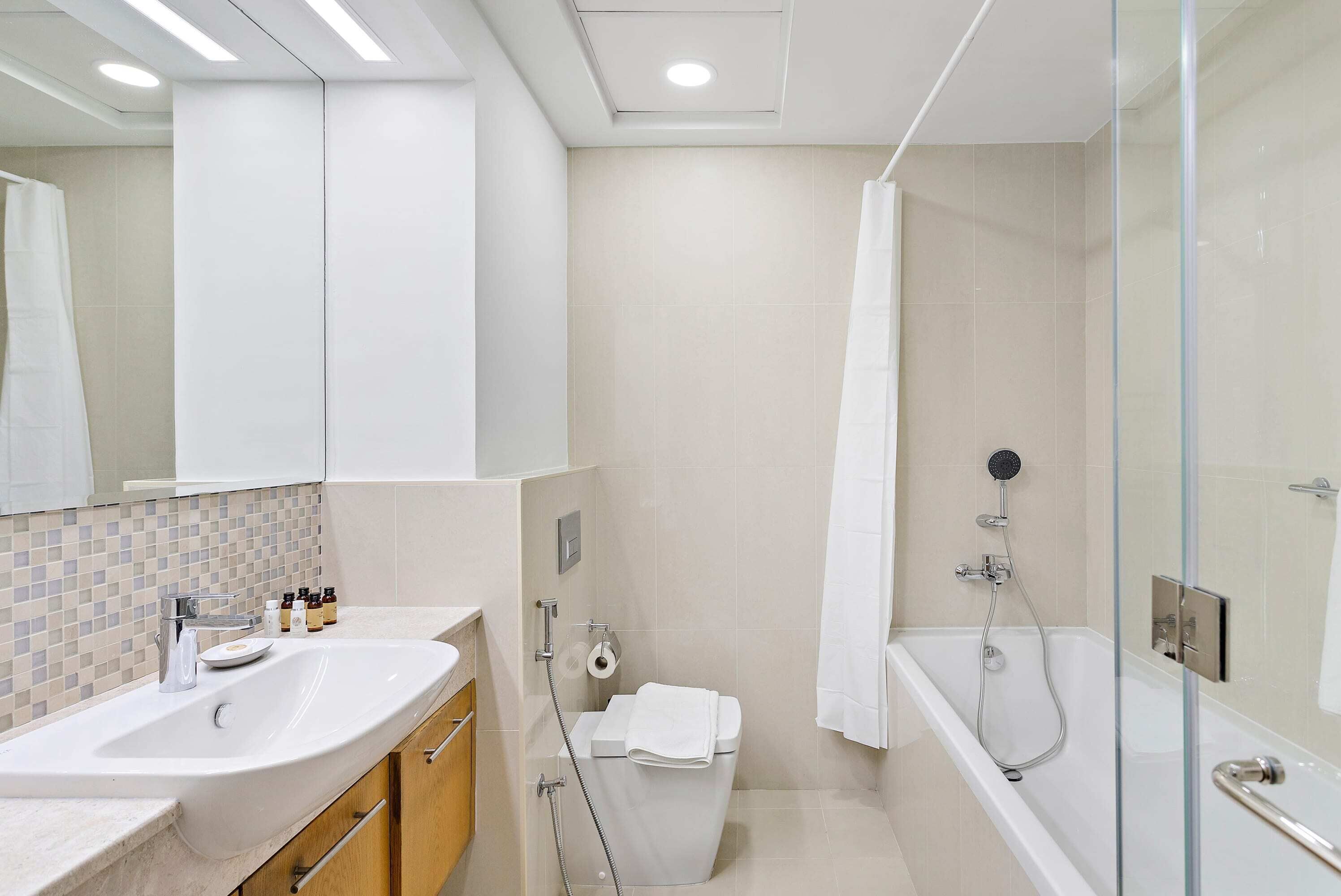 Ein modernes Badezimmer mit einem großen Waschbecken, einer Toilette und einer Badewanne.