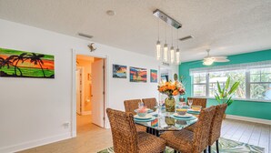 A dining area with a round table, wicker chairs, and a tropical-themed rug. - Boat Dock & Kayaks: Canalfront Home in Homosassa (Homosassa)