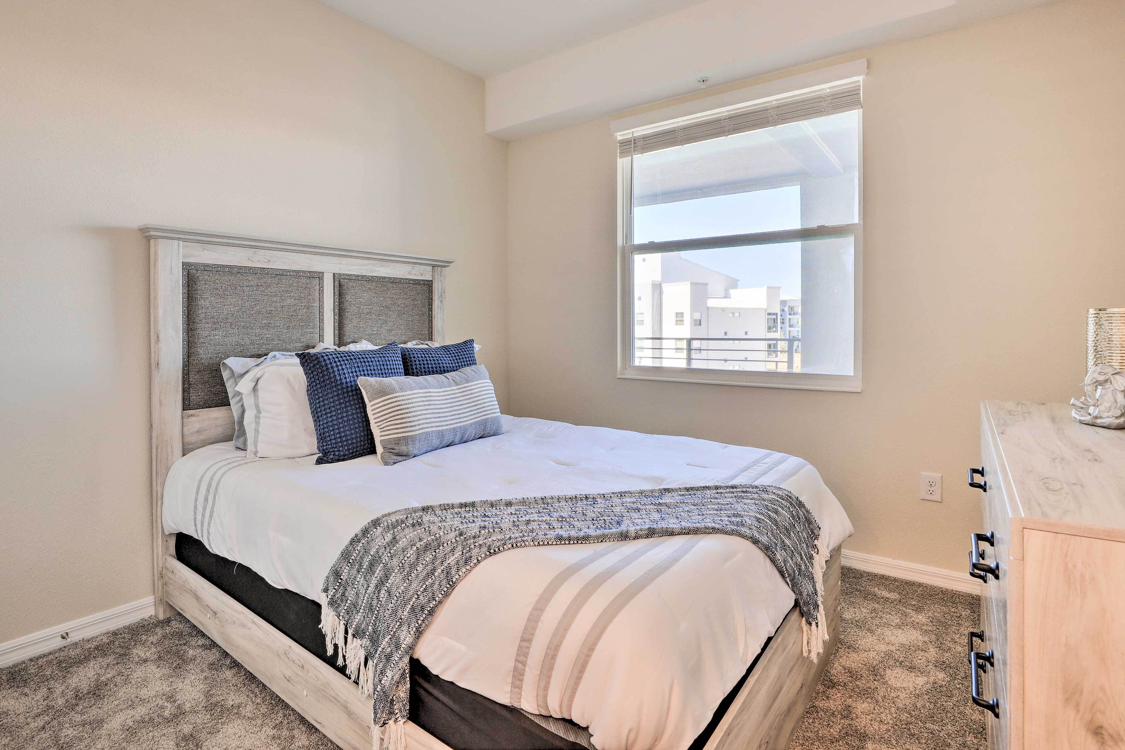 A bedroom with a bed, a window, and a dresser.