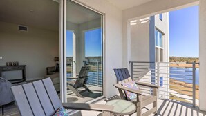 A balcony with a glass door, outdoor seating, and a view of the water. - 6 Mi to Disney: Resort Hideaway w/ Pool Access! (Kissimmee)
