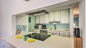 A kitchen with white cabinets, a microwave, a coffee maker, and a dishwasher.