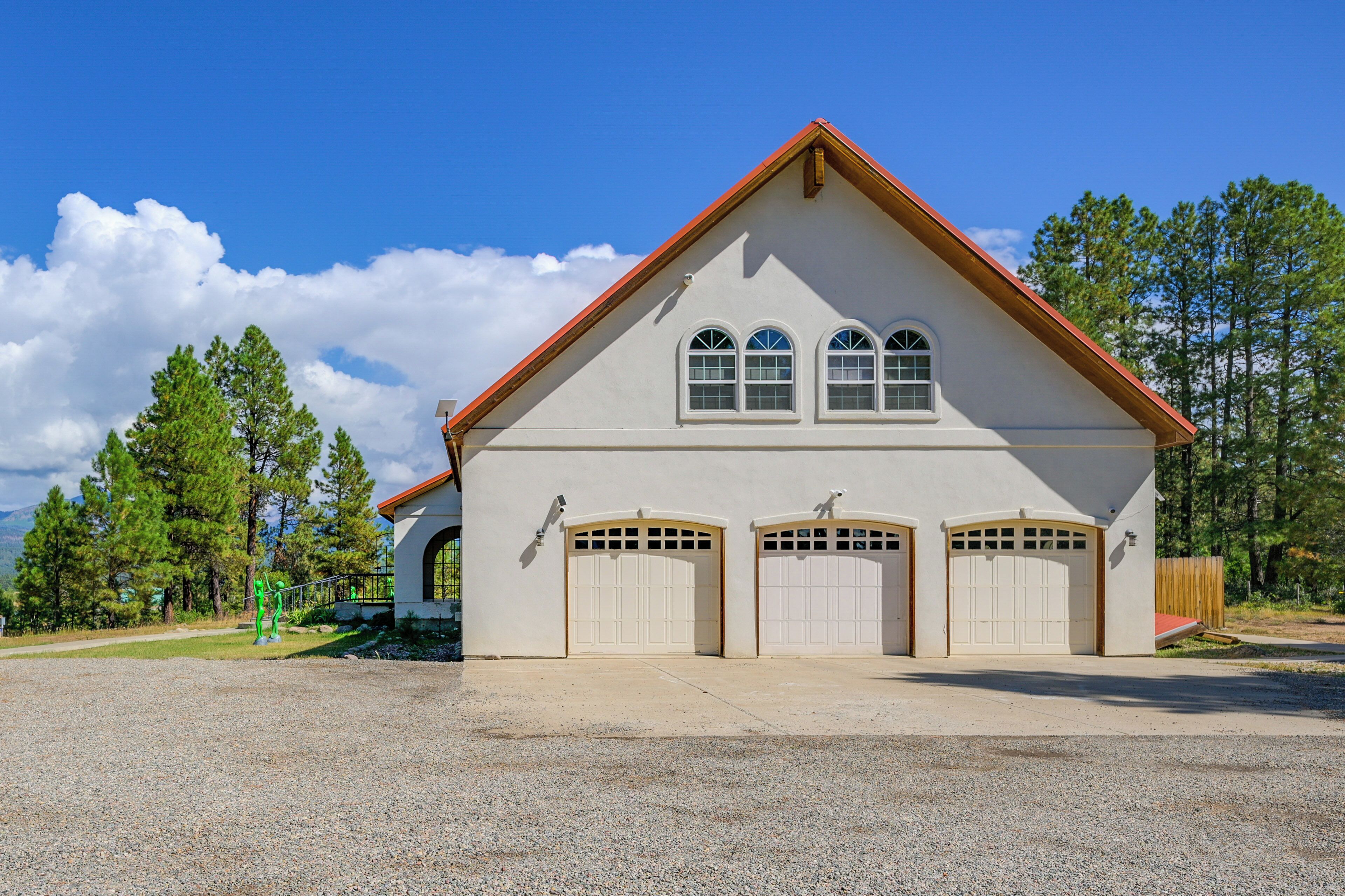 A two-story building with a red roof and three garage doors.