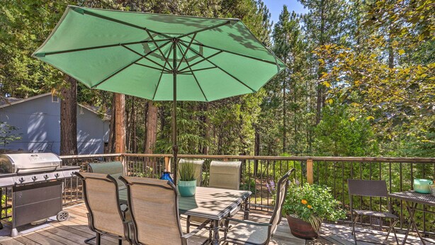 A deck with a table and chairs, a grill, and a large umbrella. - 1 Mi to Jenkinson Lake: Apples Chalet w/ Deck (Pollock Pines)