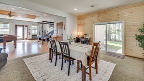 Un comedor amplio con una larga mesa, sillas de madera y vistas al exterior.