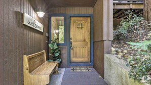 A wooden bench, a welcome sign, and a double door with a metal handle. - Tranquil Guerneville Home w/ Redwood Views (Guerneville)