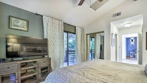 A bedroom with a large bed, a TV on a wooden cabinet, and a view of the outdoors through a sliding door. - Tranquil Guerneville Home w/ Redwood Views (Guerneville)