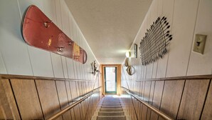 Un pasillo con paneles de madera, un monopatín rojo y un adorno en la pared.