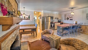 Una cocina amplia con electrodomésticos modernos, un comedor con mesa y sillas de madera, y una zona de estar acogedora con chimenea.