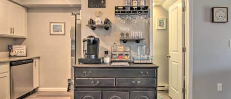 A kitchen with a coffee bar, a refrigerator, and a dishwasher.