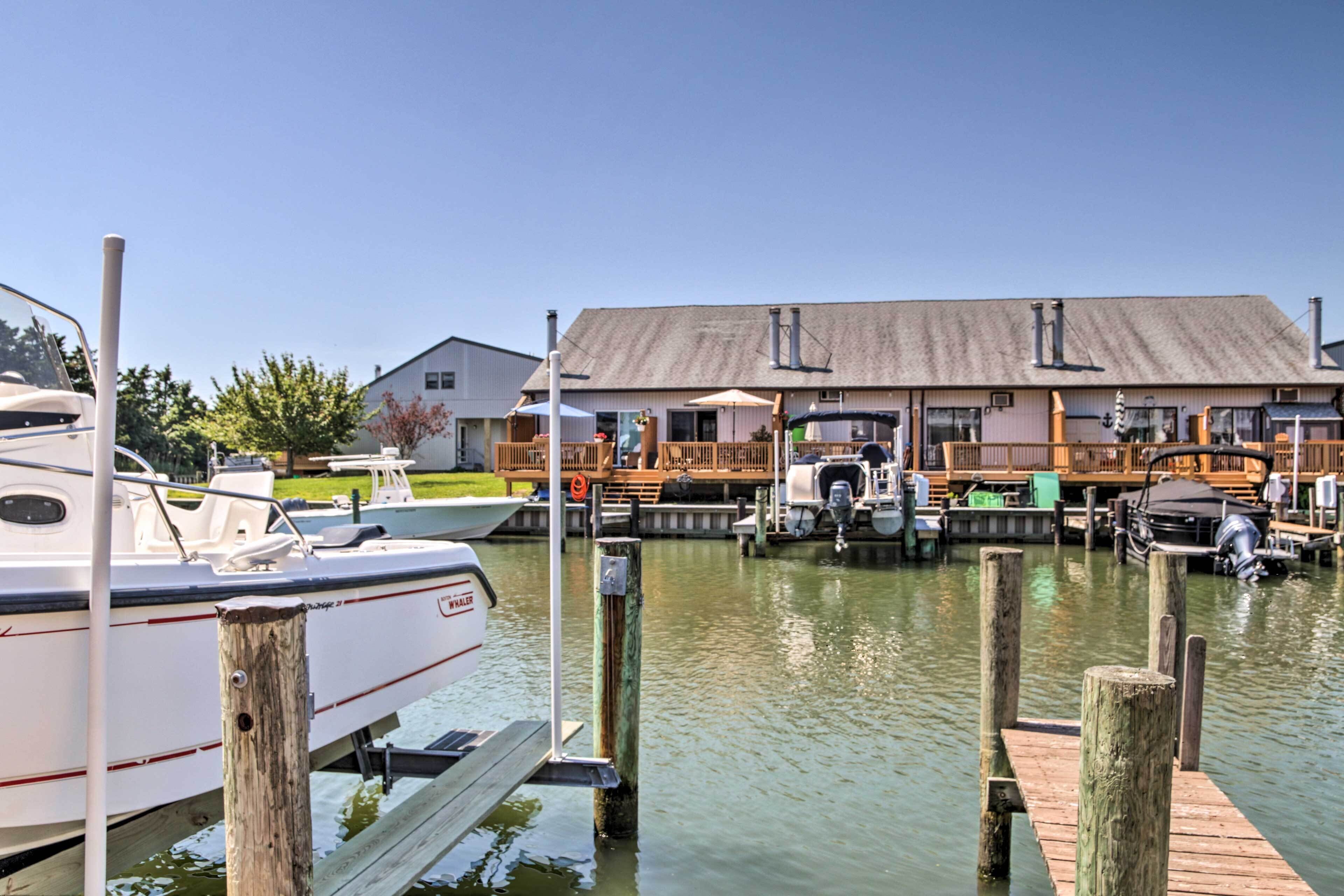 A marina with docked boats, a wooden pier, and a building with a sloped roof.