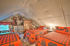 A cozy attic bedroom with two beds, a wooden wardrobe, and a window with a view. - Adirondack Mountains Cottage Near Gore Mountain! (Warrensburg)