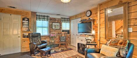 A cozy living room with a leather sofa, a recliner, a television, and a fireplace.