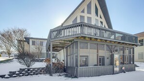 A modern building with a large glass facade, a balcony, and a snow-covered ground. - Apple Valley Home, Shared Golf Course On-site (Howard)