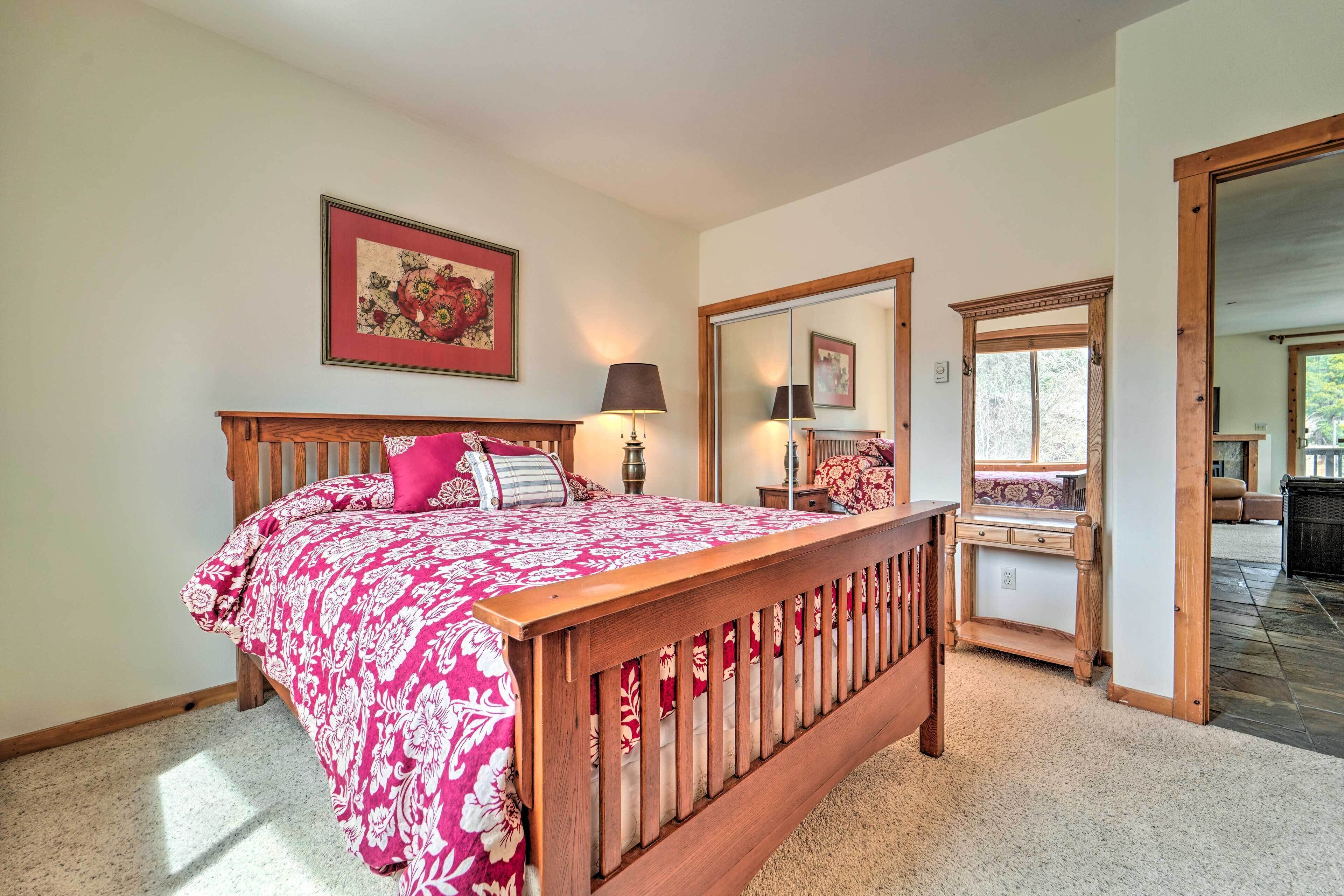 Un dormitorio con una cama de madera, un espejo grande y una ventana.