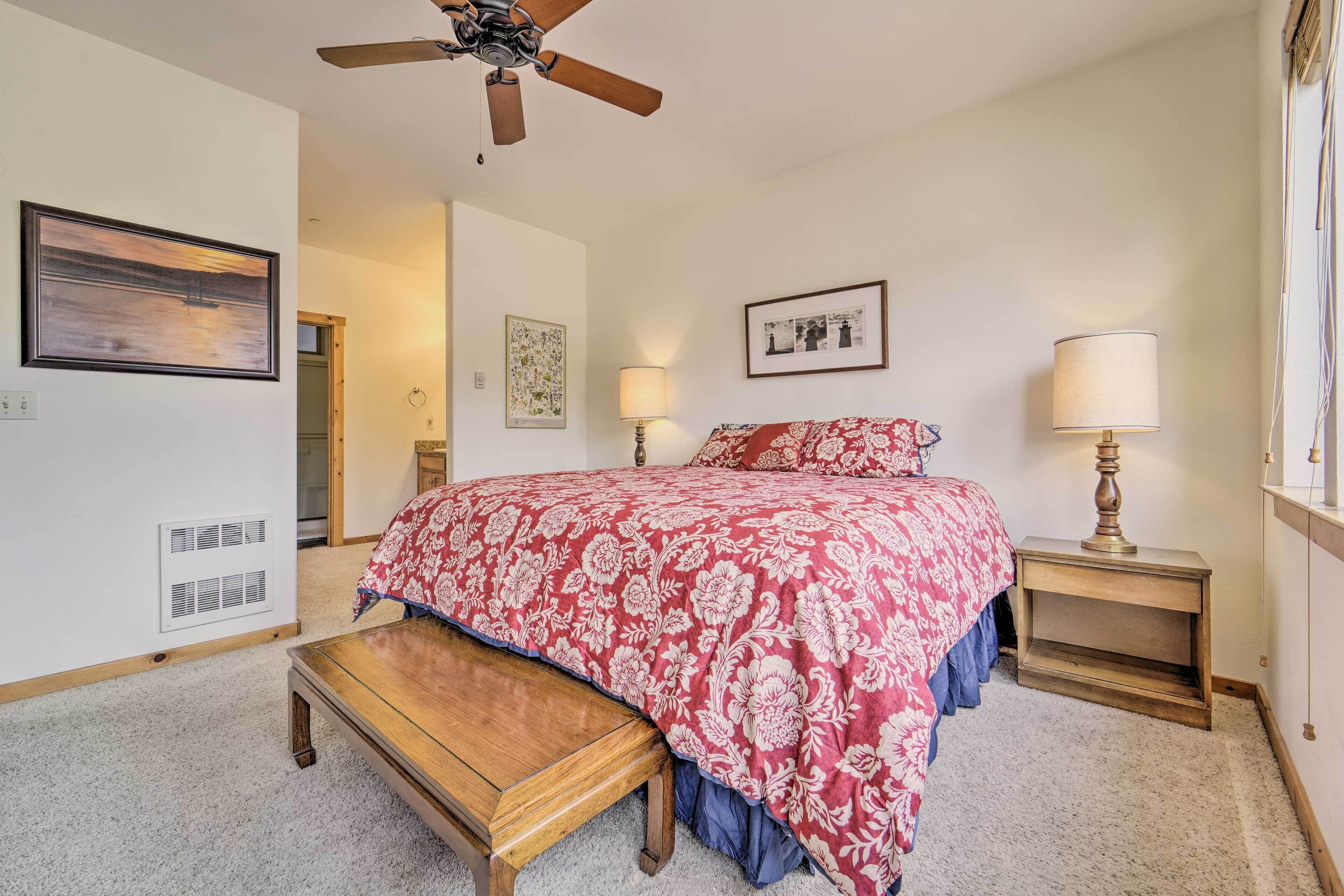 A bedroom with a bed, bedside tables, a ceiling fan, and a window.