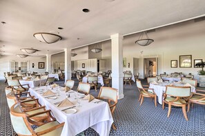 A large dining hall with multiple tables and chairs, white tablecloths, and pendant lighting. - Patio, Grill + Resort Perks: Palm Desert Home (Palm Desert)